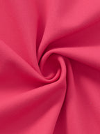 A close-up of bright pink fabric arranged in a spiral drape, showing the material texture and color.